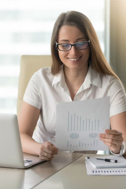 Mujer sonriente revisando un informe de resultados con gráficos en una oficina, representando la interpretación de reportes del Test de personalidad SER de Psigma Corp